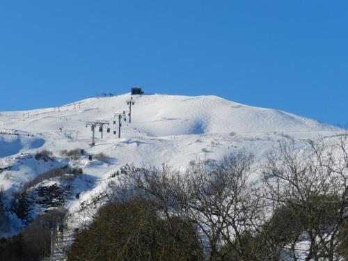 a snow covered hill with a ski lift on it at Gergovia in Super Besse