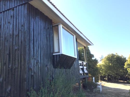 a window on the side of a wooden building at Lomita Quebrada in Pichilemu