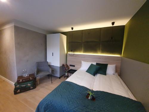 a bedroom with a large bed and a chair at Walizka Wspomnień in Karpacz