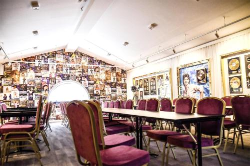 a restaurant with a table and chairs and pictures on the wall at Ursand Resort & Camping in Vänersborg