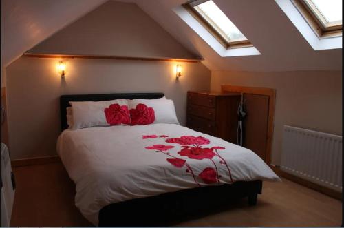 um quarto com uma cama com rosas vermelhas em killowen em Dublin