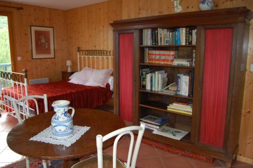 Habitación con mesa y dormitorio con cama. en L'Ardalh en Louvie Juzon