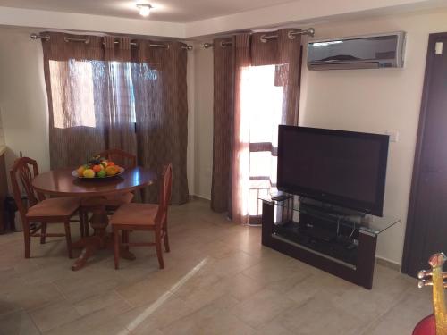 a living room with a table and a flat screen tv at Kalypso View Apartments in Letimbou