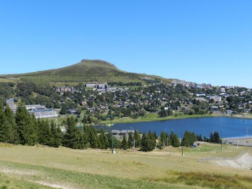 a lake in front of a mountain with a town at Gergovia in Super Besse