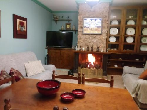 a living room with a table and a fireplace at Casa Rural El Cerrete 2 in Riópar