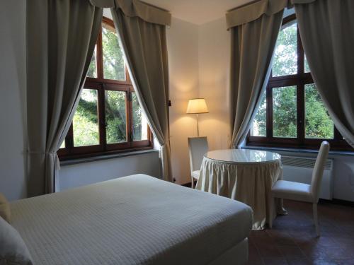a room with a table, chairs and a window at Hotel La Badia di Orvieto in Orvieto