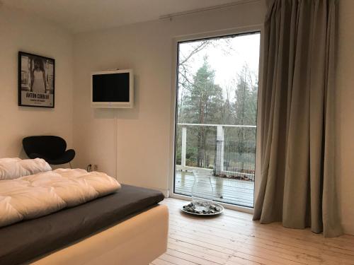 a bedroom with a bed and a large window at Country House by the lake in Hästveda