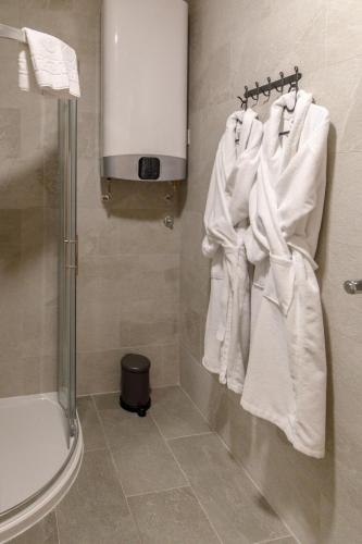 a bathroom with white towels hanging on a wall at Dali Apartments Pupin Palace in Novi Sad