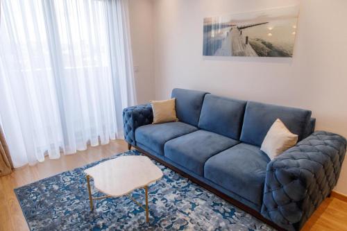 a blue couch sitting in a living room at Dali Apartments Pupin Palace in Novi Sad