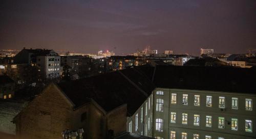 a view of a city at night with buildings at Dali Apartments Pupin Palace in Novi Sad
