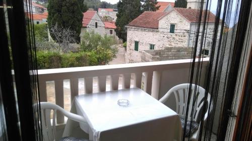 a white table and chairs on a balcony with a view at Apartments and rooms Rest - close to the sea & comfortable in Sumartin