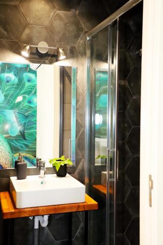 a bathroom with a sink and a shower at Le Jardin Secret de Faro Guesthouse in Faro