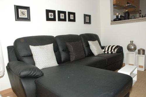 een zwarte bank in een woonkamer met een tafel bij Casa Da Canada in Seia