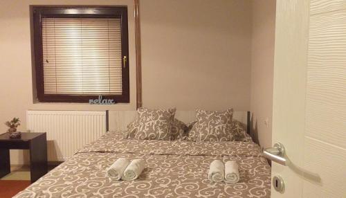 a bedroom with a bed with shoes on it at Guest house Dagovic in Bajina Bašta