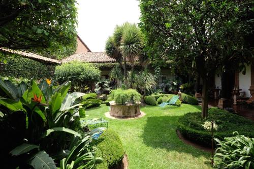 a garden with plants and trees and a house at Casa de la Real Aduana Boutique Hotel in Pátzcuaro