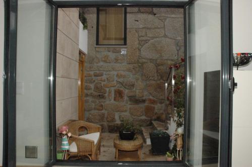 een glazen raam van een kamer met een stenen muur bij Casa Da Canada in Seia