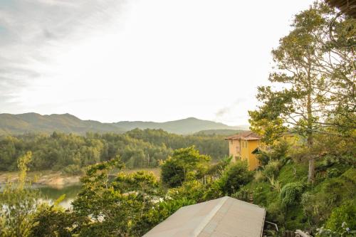 a house on a hill with a river and trees at Casa Encuentro Ecolodge, Outdoor Gym and Yoga in Guatapé