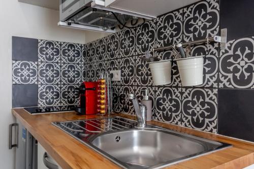 a kitchen with a sink and a black and white wallpaper at Studio - Gabriel Peri in Montrouge