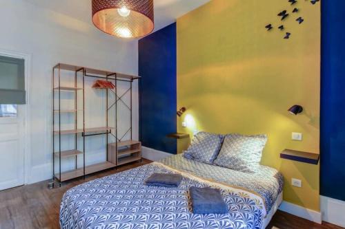 a bedroom with a bed and a blue and yellow wall at LE DORMEUR DU VAL - TOPDESTINATION DIJON - Centre ville - Classé 3 étoiles in Dijon