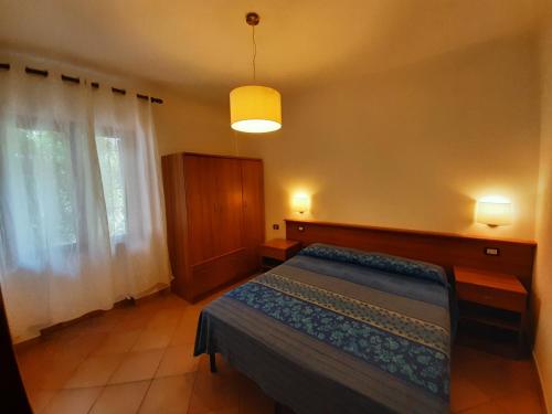 a bedroom with a bed and a large window at Villetta sul mare in Capo Vaticano