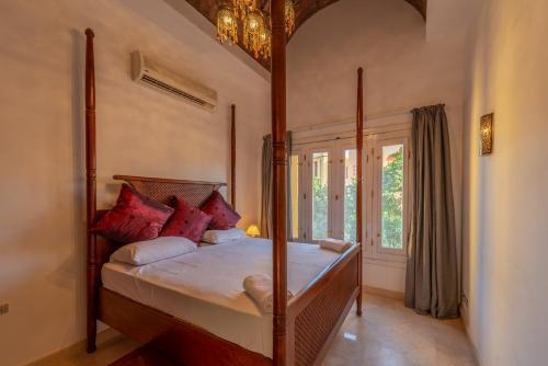 a bedroom with a canopy bed with red pillows at Beautiful Cosy 3 bedroom townhouse in South Marina in Hurghada