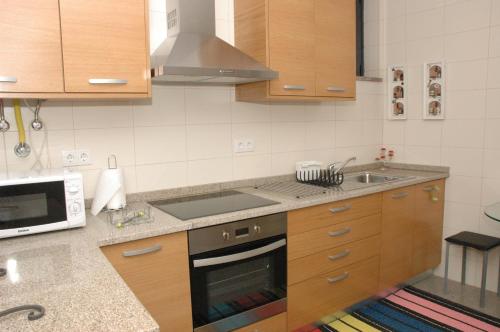 a kitchen with a stove and a sink and a microwave at Casa Da Canada in Seia