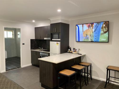 a kitchen with a counter and a tv on the wall at Best Western Plus All Settlers Motor Inn in Tamworth