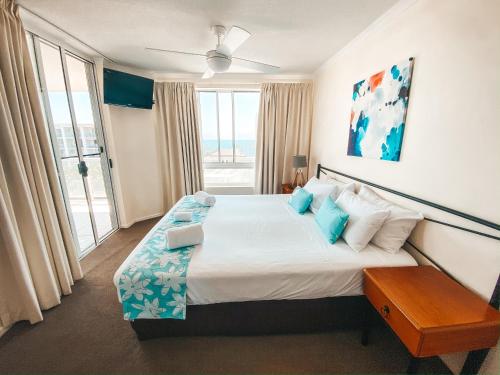 Un dormitorio con una cama grande con una ventana grande. en Bargara Blue Resort, en Bargara