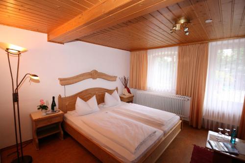 a bedroom with a large bed with a wooden ceiling at Landhaus Lebert Restaurant in Windelsbach
