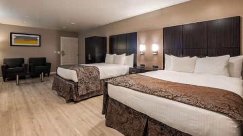 a hotel room with two beds and a chair at SureStay Plus by Best Western Santa Clara Silicon Valley in Santa Clara