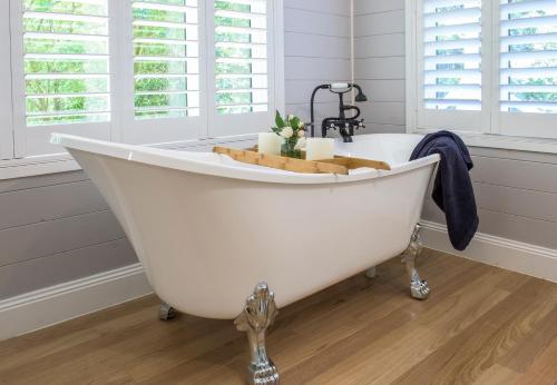 a white bath tub in a bathroom with windows at Franklin - An Escape to the Country in Sassafras