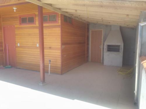 uma grande garagem com paredes de madeira e uma porta em Casa de férias flor das acácias em Urubici