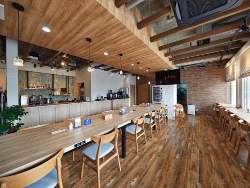 a large long table in a restaurant with chairs at CABIN&HOTEL ReTIME in Naha