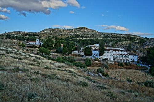 a house on a hill with a mountain in the background at Balneario de Alicún de las Torres in Villanueva de las Torres