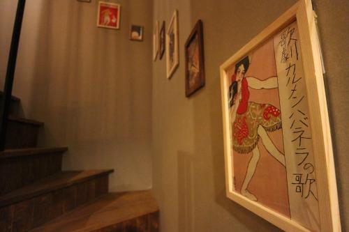 a hallway with a painting of a woman on the wall at SHARIN in Kanazawa