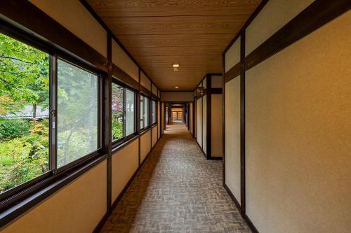 a corridor of a building with windows and a hallway at Furusato in Takayama