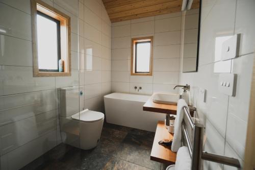 a bathroom with a tub and a toilet and a sink at Alpine Lodges in Lake Tekapo