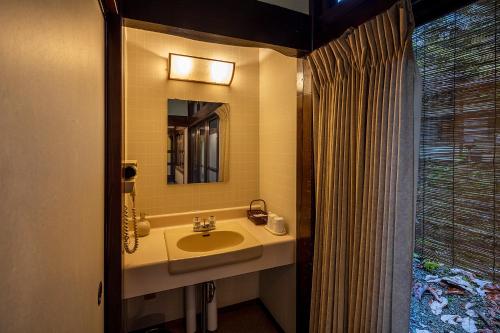 a bathroom with a sink and a mirror and a window at Furusato in Takayama