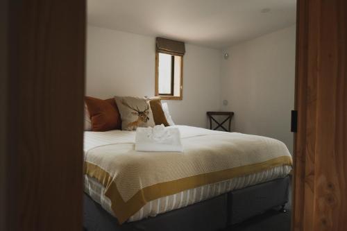 a bedroom with a bed with a towel on it at Alpine Lodges in Lake Tekapo