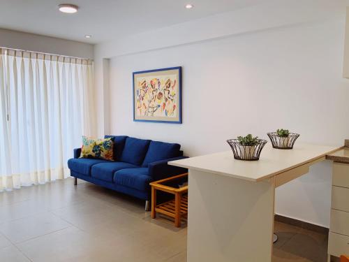 a living room with a blue couch and a table at Mar , Familia & Diversion en San Bartolo in San Bartolo