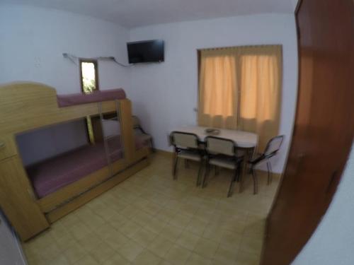 a room with a bed and a table and chairs at Adela Miramar - Buenos Aires in Miramar