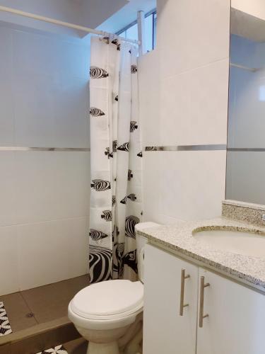 a white bathroom with a toilet and a sink at Mar , Familia & Diversion en San Bartolo in San Bartolo