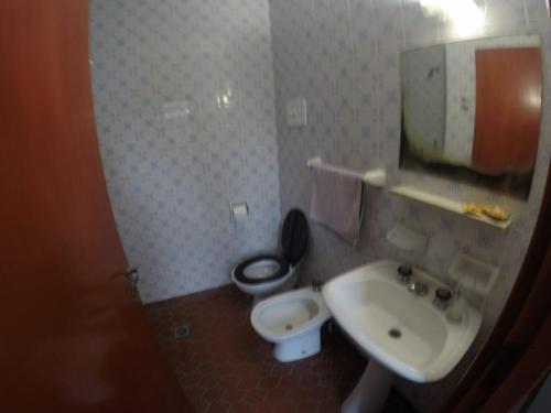 a bathroom with a toilet and a sink at Adela Miramar - Buenos Aires in Miramar