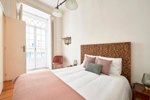 a bedroom with a large bed with a large window at Spacious Apartment in the Perfect Lisbon Location, By TimeCooler in Lisbon