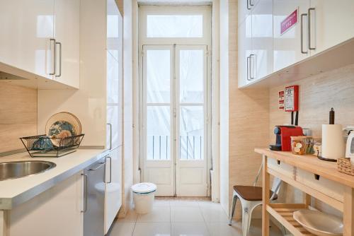 a kitchen with a sink and a large window at Spacious Apartment in the Perfect Lisbon Location, By TimeCooler in Lisbon