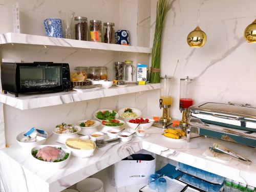 a kitchen with plates of food on shelves at Hanoi La Selva Central Hotel & Spa in Hanoi