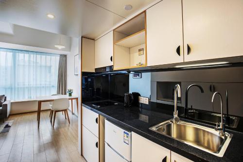a kitchen with a sink and a counter top at Livefortuna Hotel in Beijing