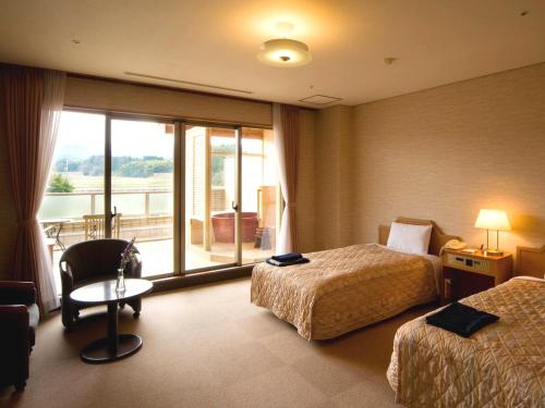 Habitación de hotel con 2 camas y ventana en Tsurugi Koizuki, en Kamiichi