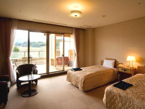 a hotel room with two beds and a window at Tsurugi Koizuki in Kamiichi