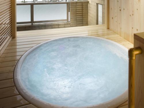 a large blue bath tub in a room with a window at Tsurugi Koizuki in Kamiichi